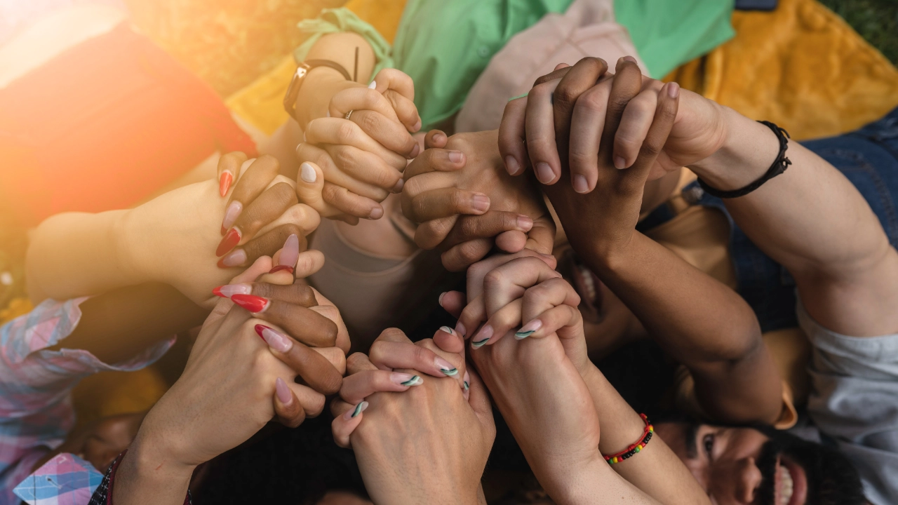 Viele Hände mit vielen Hautfarben vereint ineinander gefaltet.